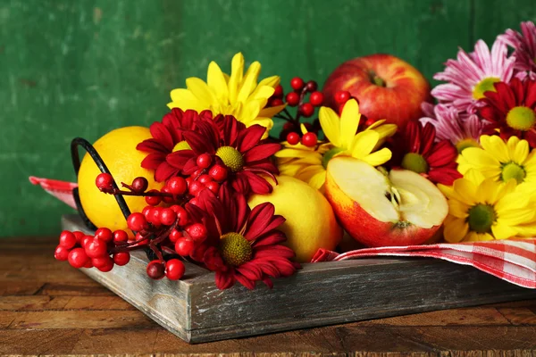 Komposition mit Chrysanthemen und Früchten auf Holzgrund — Stockfoto