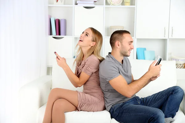 Young couple after quarrel sending to each other messages at home — Stock Photo, Image