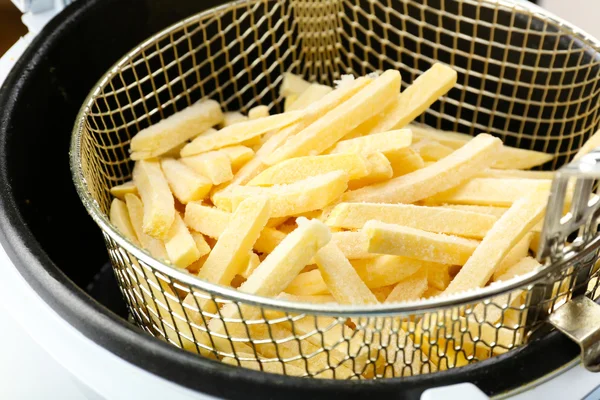 French fries in deep fryer — Stock Photo, Image