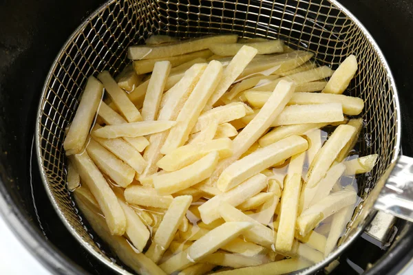 French fries in deep fryer — Stock Photo, Image