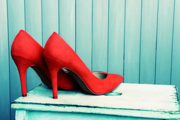 Mulheres sapatos vermelhos no fundo de madeira — Fotografia de Stock