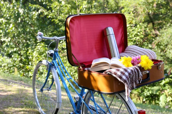 Велосипед и открытый чемодан — стоковое фото