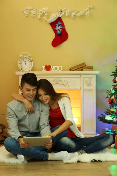 Paar in de buurt van open haard met Tablet PC — Stockfoto