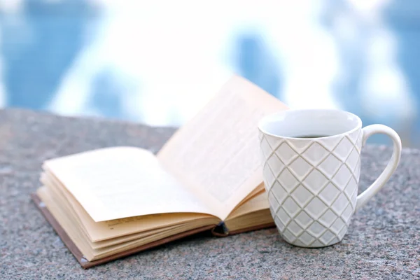 Cup met warme dranken en boek — Stockfoto