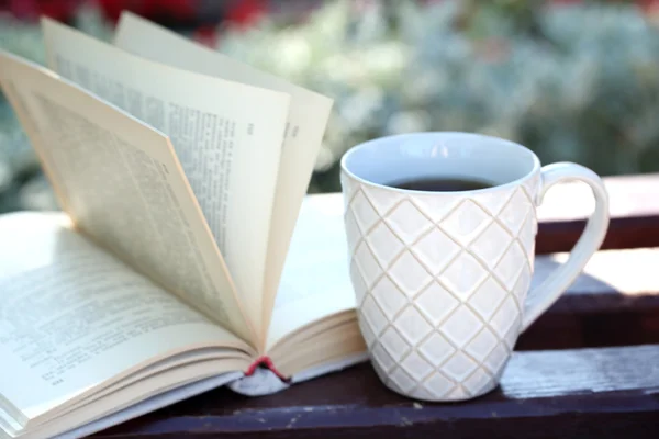 Copo com bebida quente e livro — Fotografia de Stock