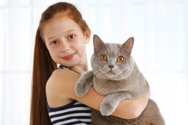Güzel küçük bir kız ile ışık arka plan üzerinde kedi