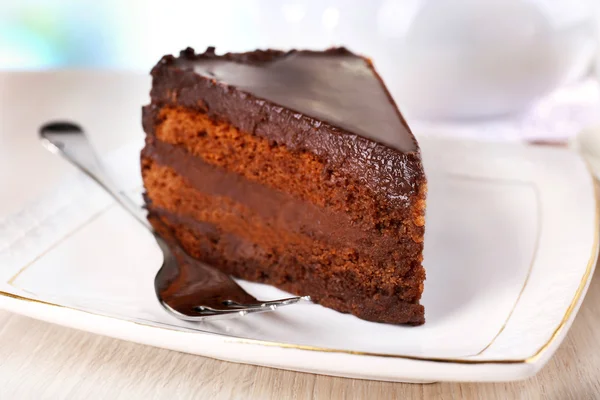 Pedazo de pastel de chocolate en platillo sobre fondo claro —  Fotos de Stock