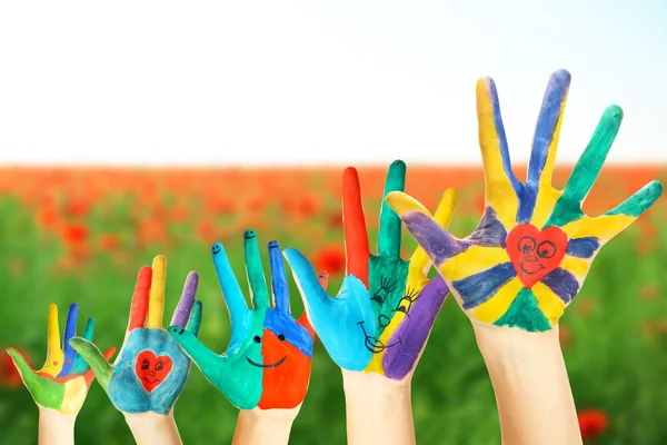 Painted hands on field — Stock Photo, Image