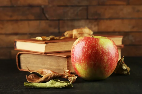 Manzana con libros y hojas secas —  Fotos de Stock