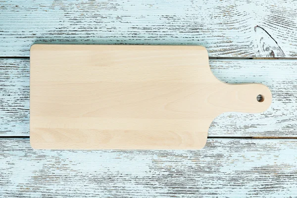 Cutting board on wooden background — Stock Photo, Image