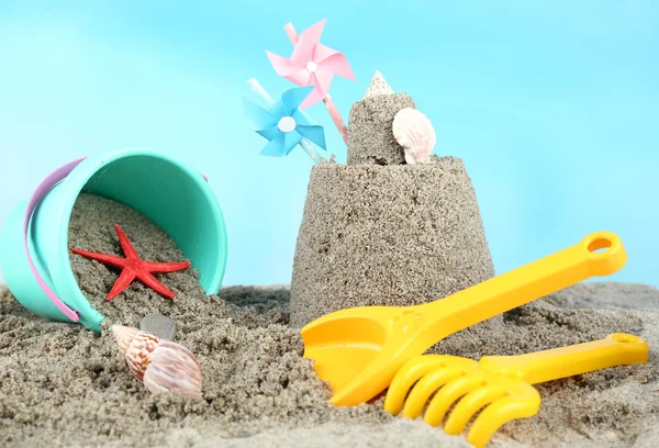 Sandcastle with pinwheel on beach — Stock Photo, Image