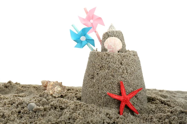 Sandcastle with pinwheel on sandy beach — Stock Photo, Image