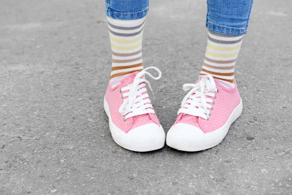 Frauenbeine in bunten Socken und Turnschuhen — Stockfoto