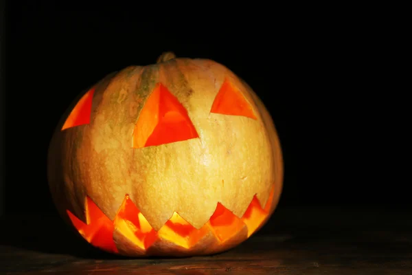 Calabaza de Halloween sobre mesa de madera, sobre fondo oscuro —  Fotos de Stock