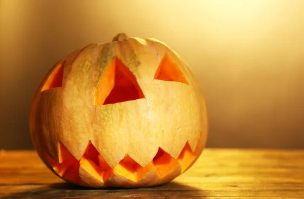Halloween pumpa på träbord, på färgbakgrund — Stockfoto