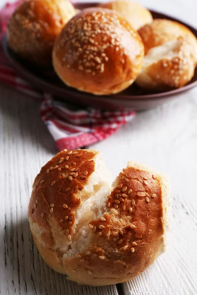 Pães saborosos com gergelim na placa — Fotografia de Stock