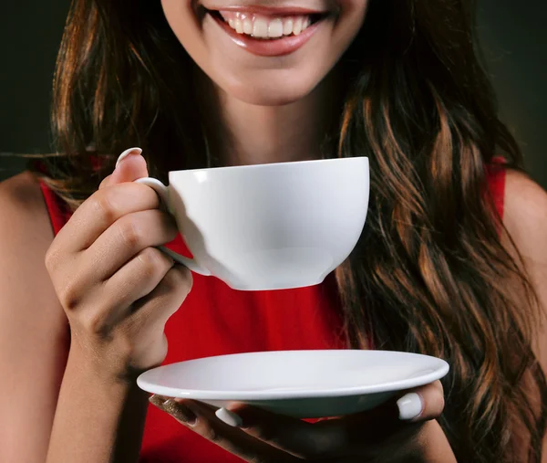 Mooi meisje met kop koffie op bruine achtergrond — Stockfoto