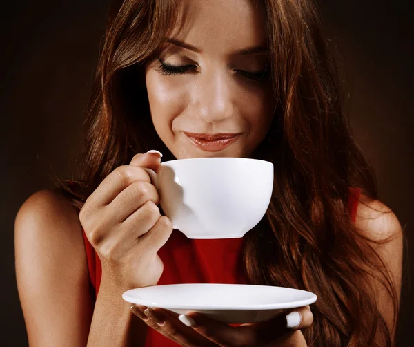 Hermosa joven con taza de café sobre fondo marrón — Foto de Stock