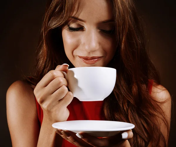 Hermosa joven con taza de café sobre fondo marrón —  Fotos de Stock