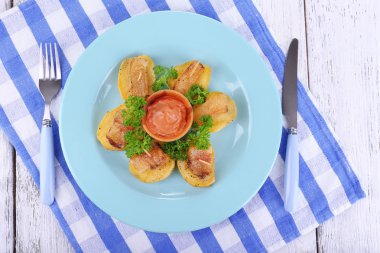 fırında patates tabakta ahşap zemin üzerine pastırma ile