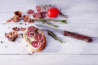 Sandviç salam, biberiye ve ceviz ahşap arka plan üzerinde