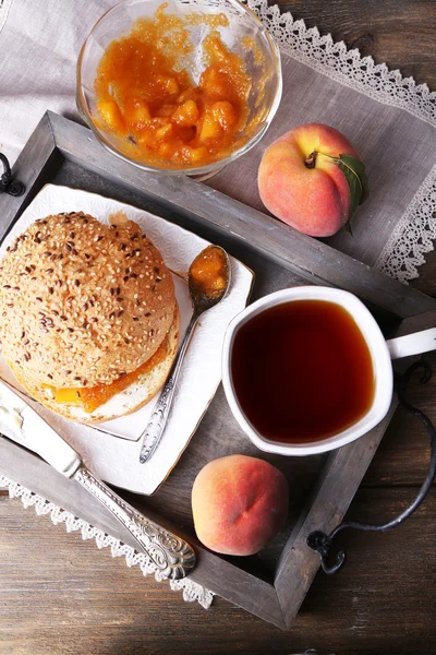 Leichtes Frühstück mit Tasse Tee und hausgemachter Marmelade auf Holztisch — Stockfoto