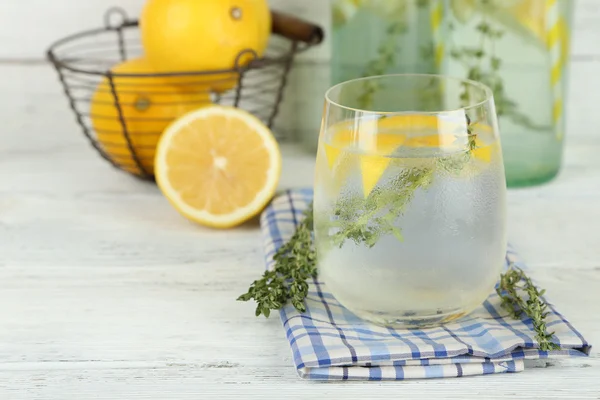 Smakelijke koele drank met citroen en tijm, op houten achtergrond — Stockfoto