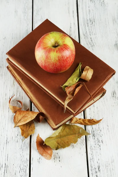 Apple with books and dry leaves — Stock Photo, Image