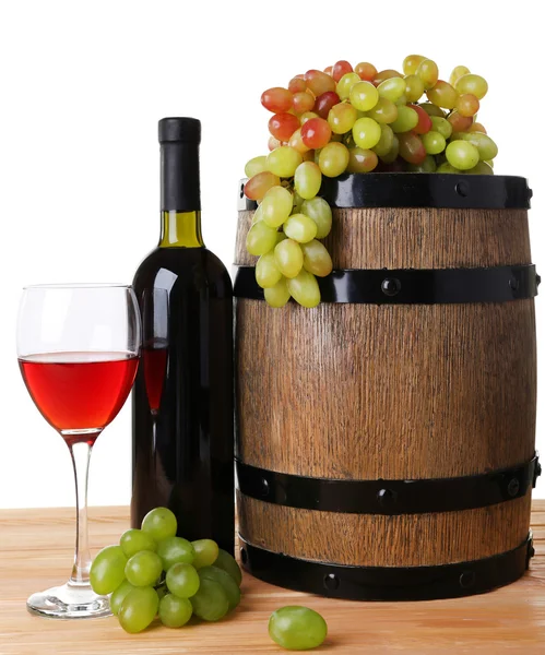 Vin en gobelet et en bouteille, raisin et tonneau sur table en bois sur fond blanc — Photo