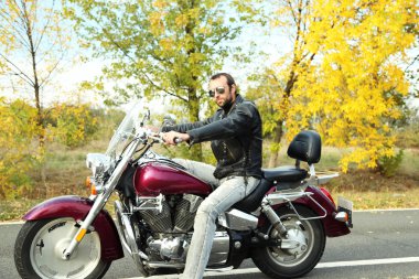 Motorcu adam bisiklet üzerinde oturur