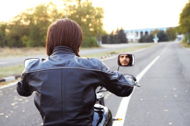 Motorcu adam bisiklet üzerinde oturur