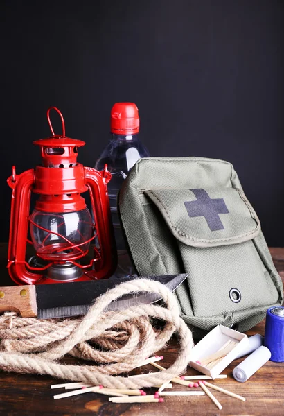 Equipamento de preparação de emergência na mesa de madeira, no fundo escuro — Fotografia de Stock