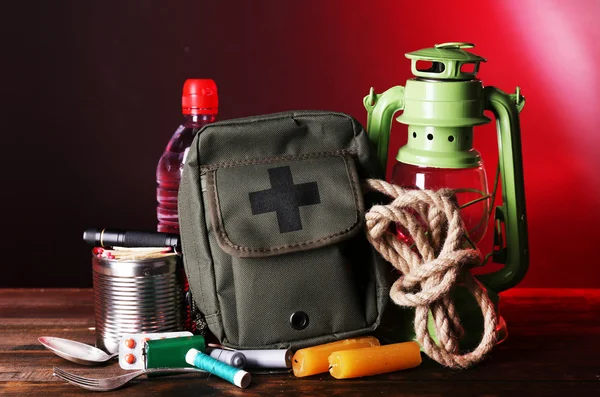 Equipamento de preparação de emergência na mesa de madeira, no fundo escuro — Fotografia de Stock