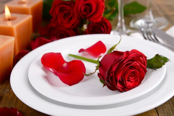 Configuração de mesa com rosa vermelha na placa — Fotografia de Stock