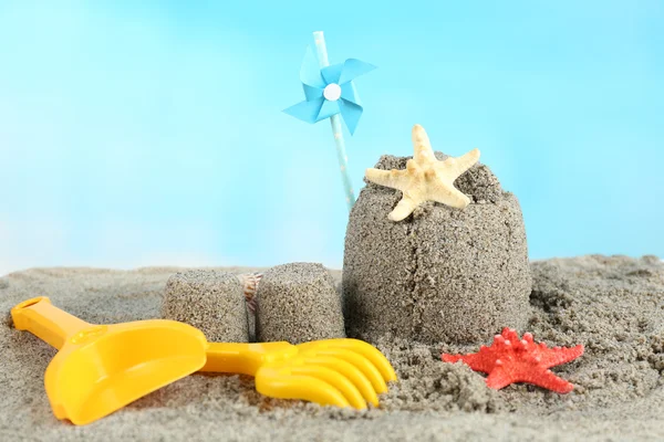 Sandcastle with pinwheel on sandy beach — Stock Photo, Image