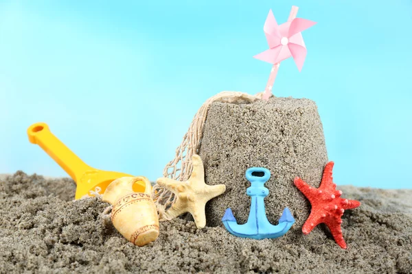 Sandcastle com pinwheel na praia arenosa — Fotografia de Stock