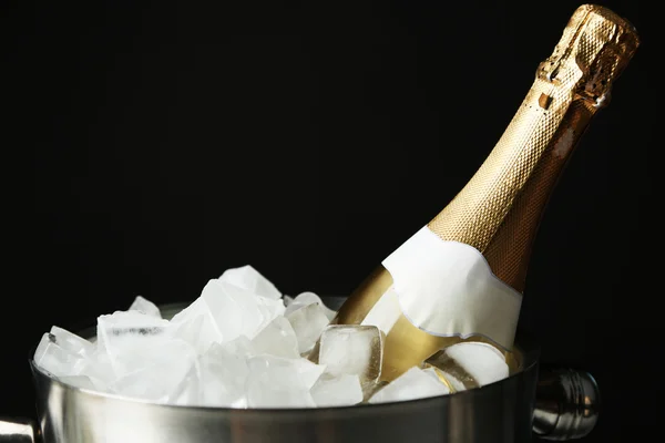 Garrafa de champanhe em balde com gelo, sobre fundo preto — Fotografia de Stock