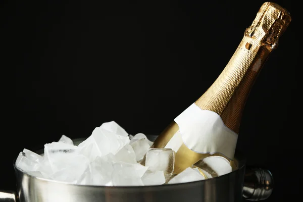 Botella de champán en cubo con hielo, sobre fondo negro —  Fotos de Stock