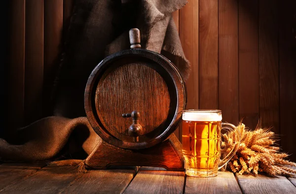 Barril de cerveza con vaso de cerveza en la mesa sobre fondo de madera — Foto de Stock