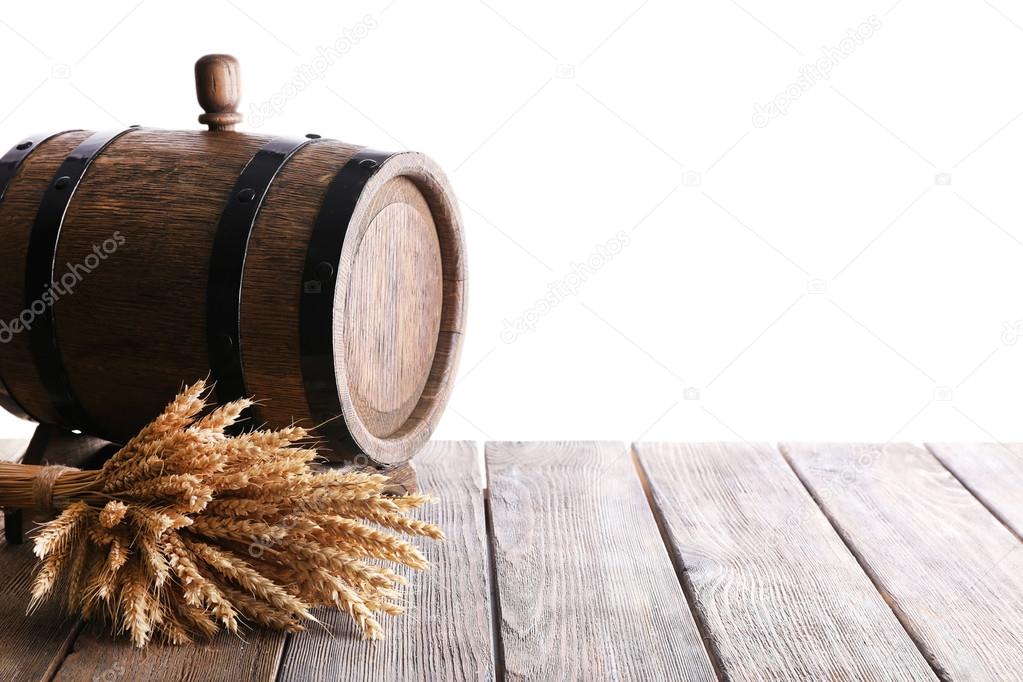 Old barrel with wheat on table on white background