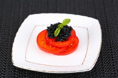 Siyah havyar ile domates dilimleri