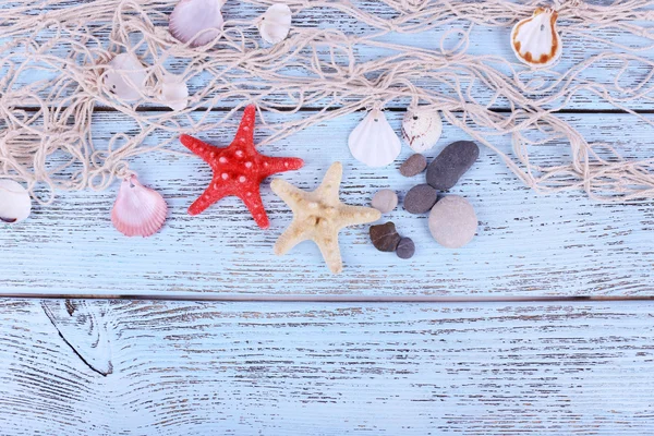 Decoração de conchas e seastar close-up em mesa de madeira azul — Fotografia de Stock