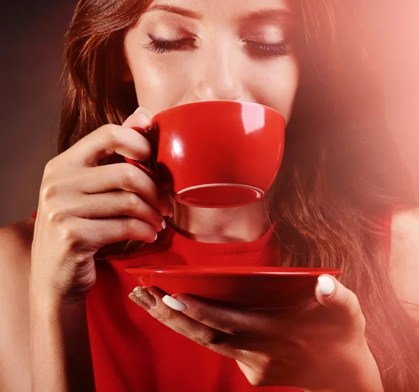 Hermosa joven con taza de café sobre fondo marrón — Foto de Stock