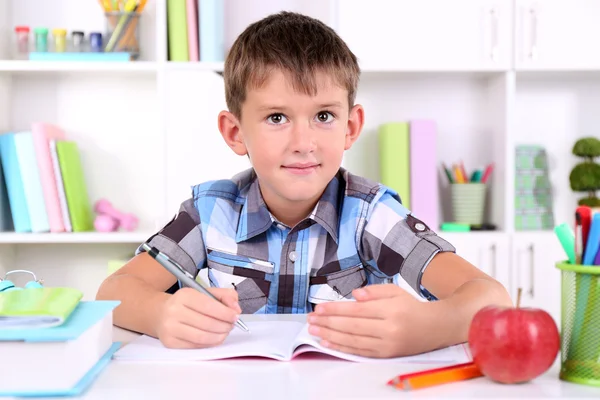 Schoolboy sitting at table in classroom — Stock Photo, Image