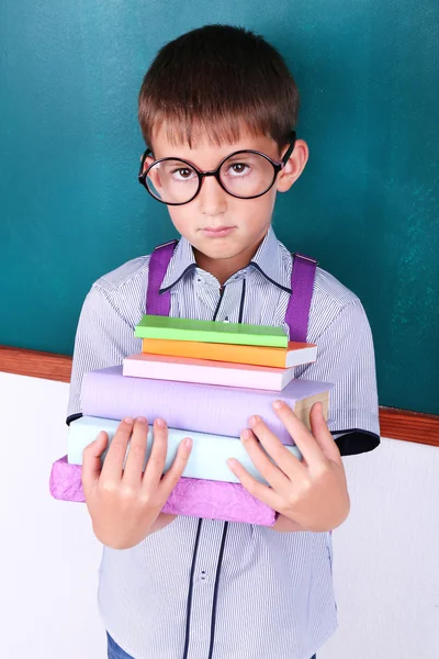 Schoolboy at blackboard in classroom — Stock Photo, Image