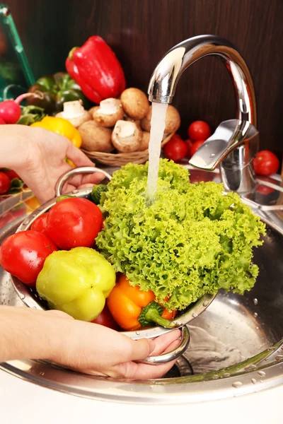 Жіночі руки миють овочі в раковині на кухні — стокове фото