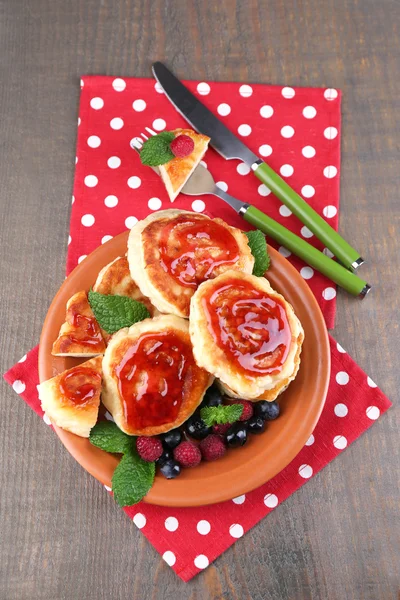 Tasty pancakes with fresh berries, honey and mint leaf on plate, on  wooden background — Stock Photo, Image