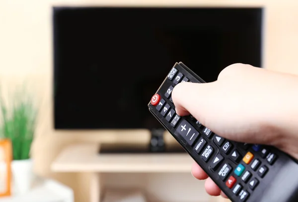 Watching TV and using remote controller — Stock Photo, Image