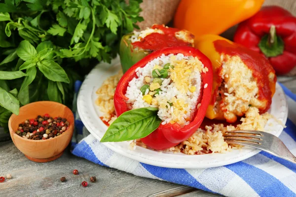 Composition with prepared stuffed peppers on plate and fresh herbs, spices and vegetables, on wooden background — Stock Photo, Image