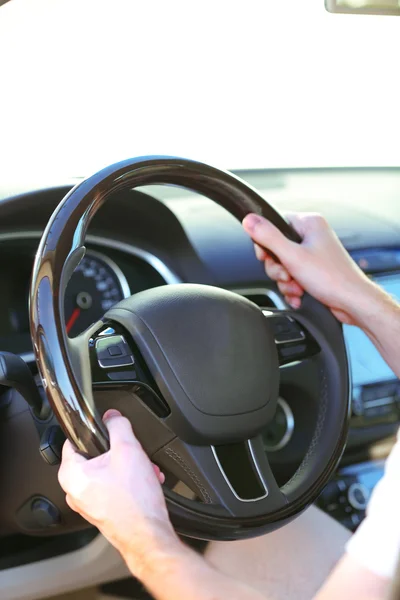 Man's hands on a steering wheel Stock Image